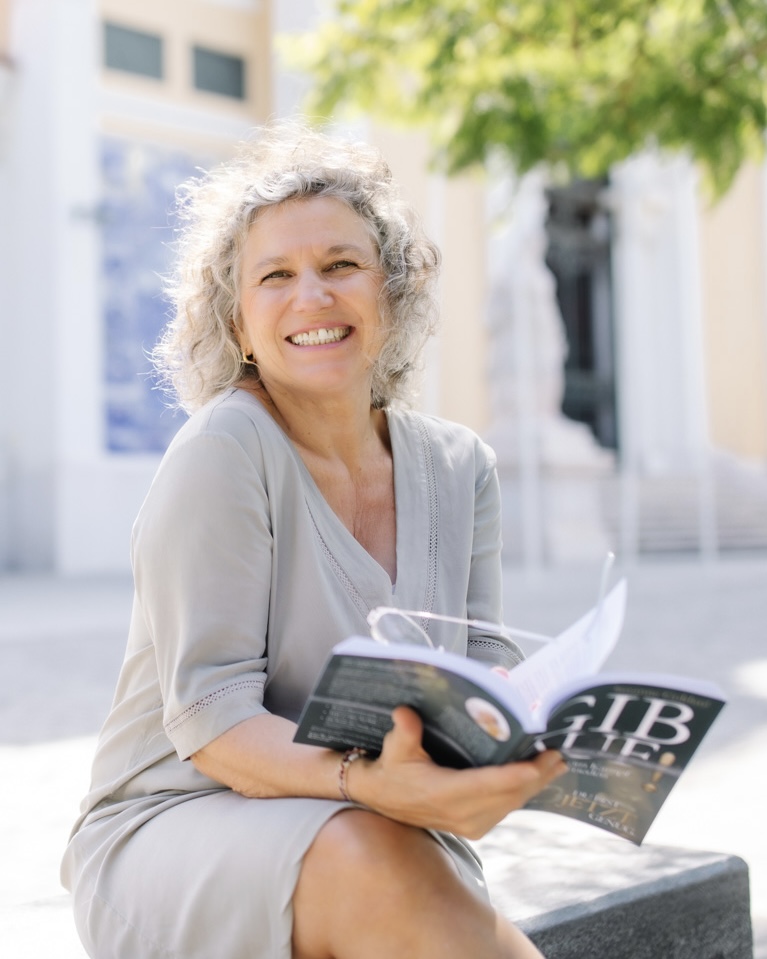 Susanne Goldaté lächelnd mit ihrem Buch "Gib Auf!"